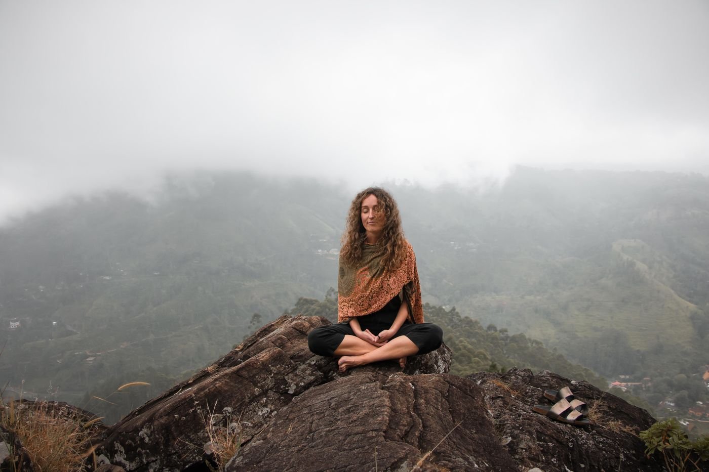 Femme méditant paisiblement au sommet d'une montagne